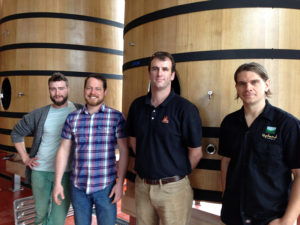 Caleb and his team in front of new foudres in the expanding sour brewery.